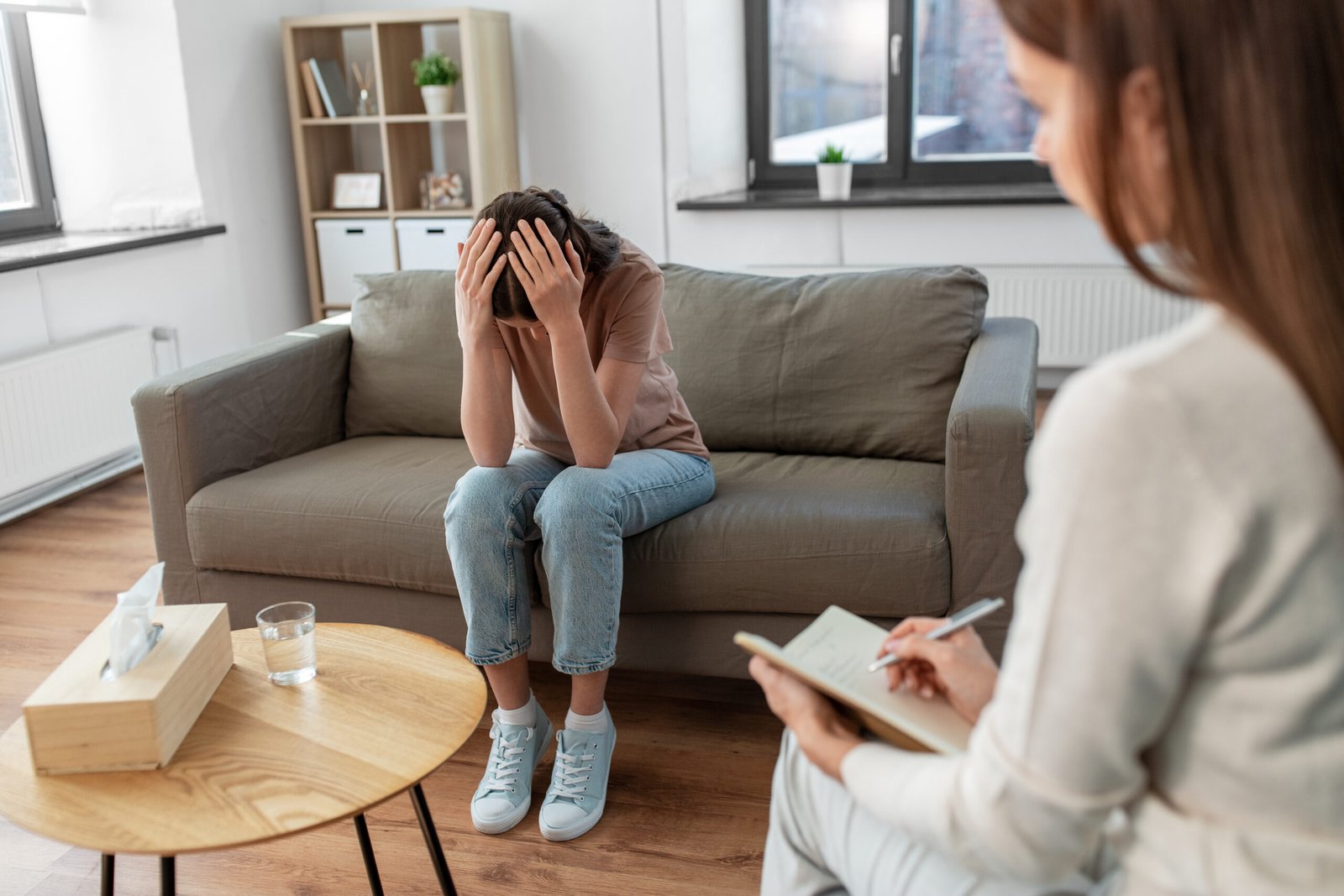 psychology, mental health and people concept - stressed young woman patient and psychologist at psychotherapy session